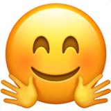 Fröhliches Gesicht mit umarmenden Händen Emoji auf Apple macOS und iOS iPhones